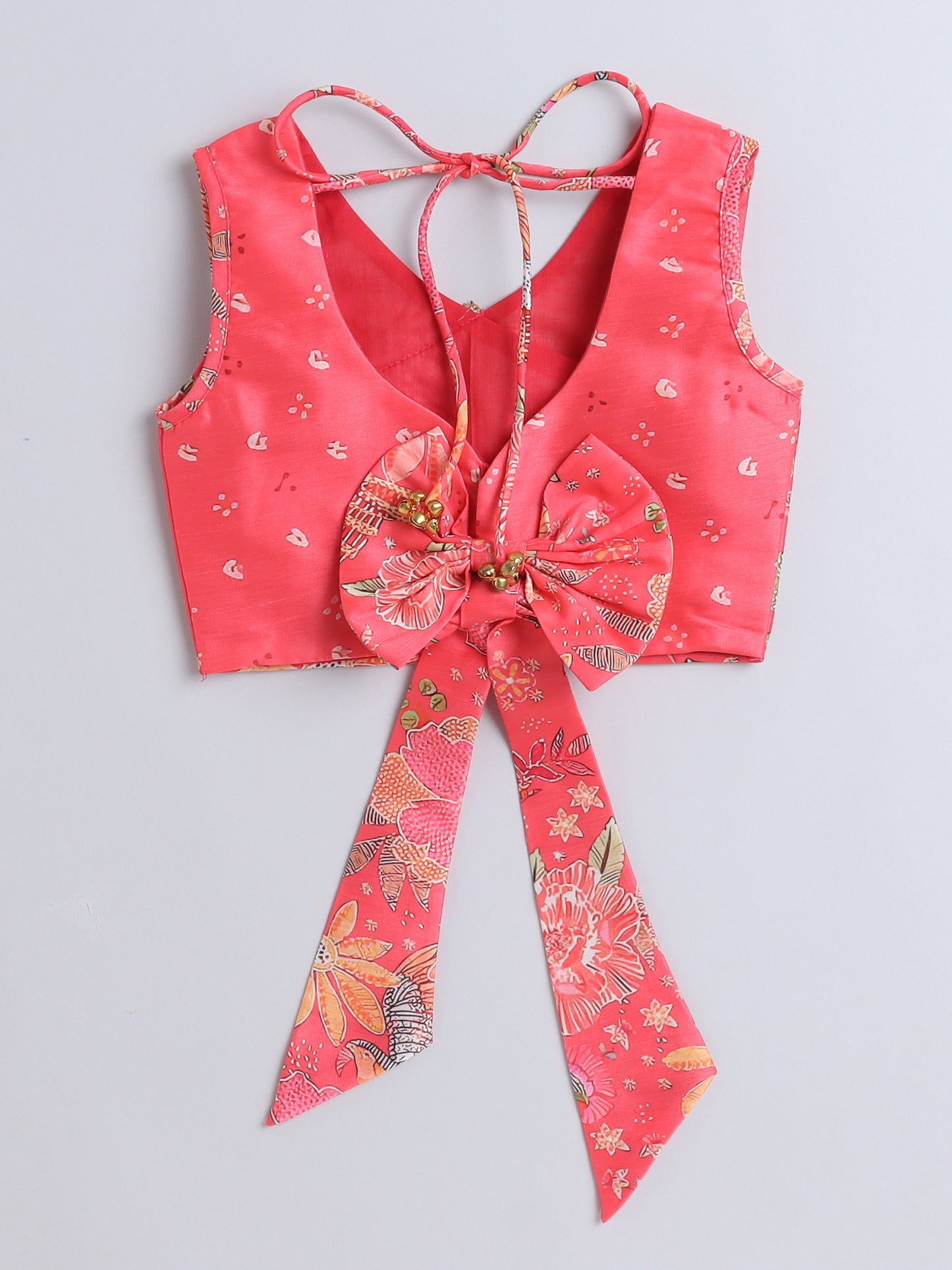 Red floral patterned top with a large bow on a light gray background