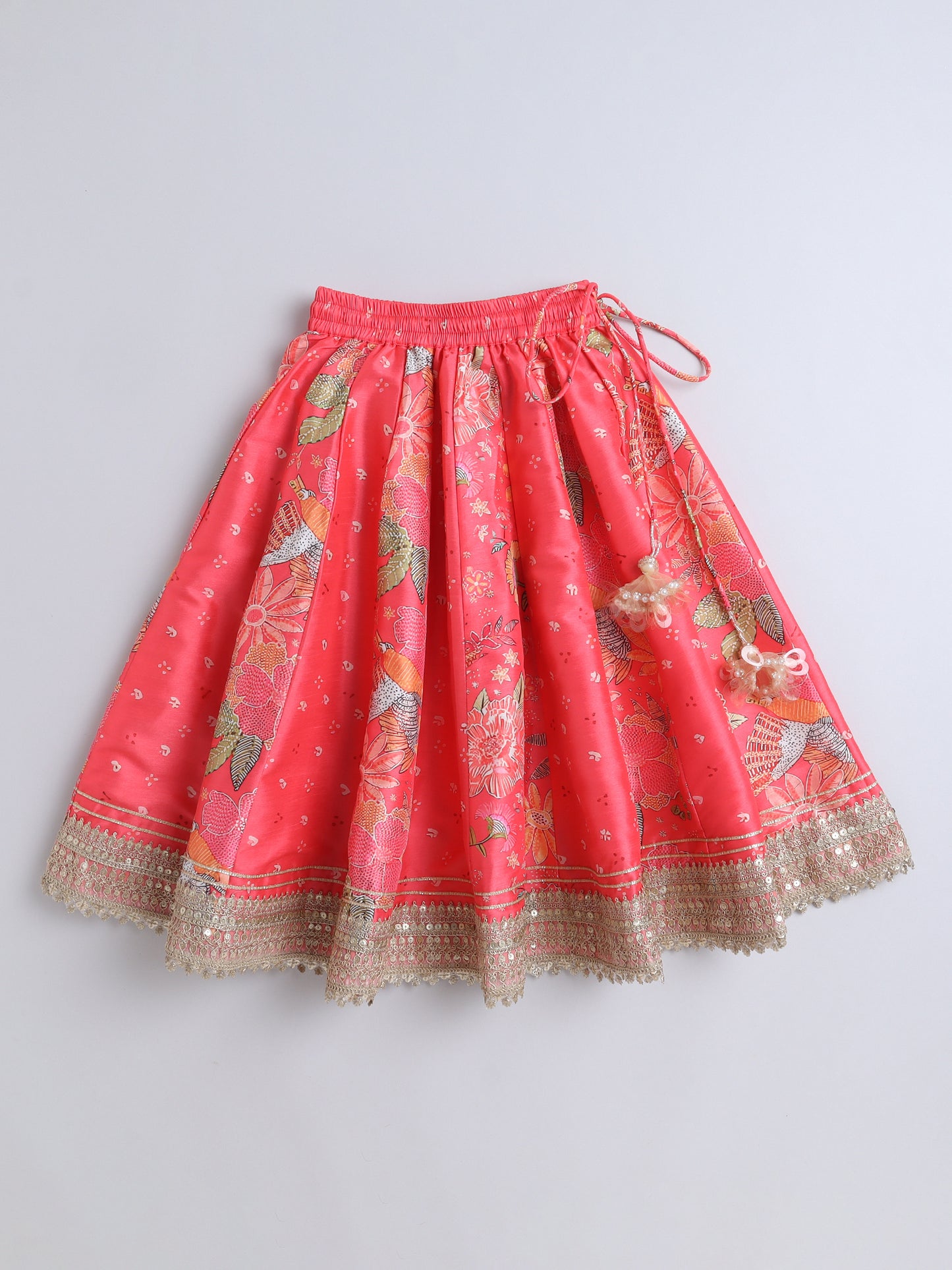 Red skirt with floral patterns and gold trim on a light gray background