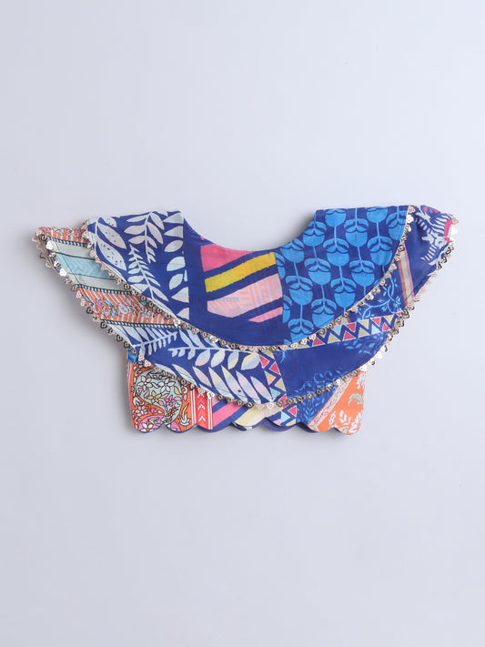 Colorful cowl blouse with geometric patterns on a blue background