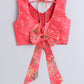 Red floral patterned top with a large bow on a light gray background