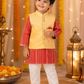 Child wearing a traditional outfit with a yellow vest and red shirt in a decorated setting.