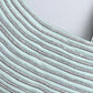 Close-up of a textured fabric with horizontal stripes on a light blue background
