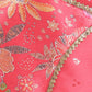 Close-up of a pink fabric with floral patterns and gold trim