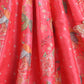 Red fabric with intricate gold and white floral patterns