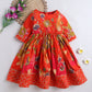 Red floral dress on a white background with decorative elements.