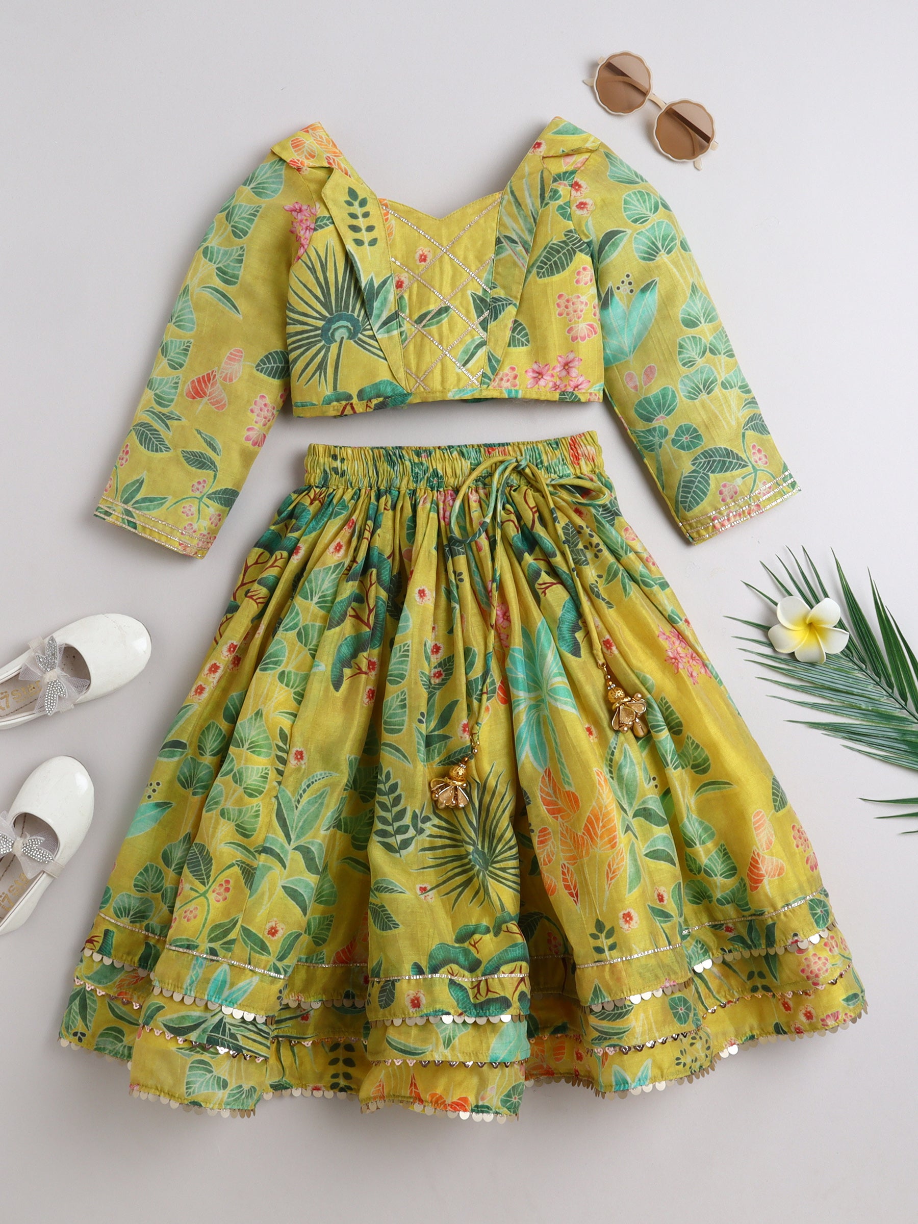 Yellow floral outfit with a top and skirt on a light gray background