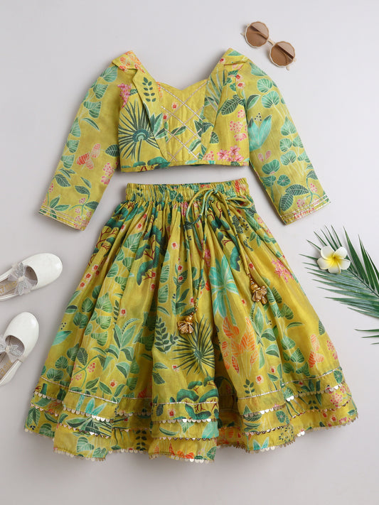 Yellow floral outfit with a top and skirt on a light gray background