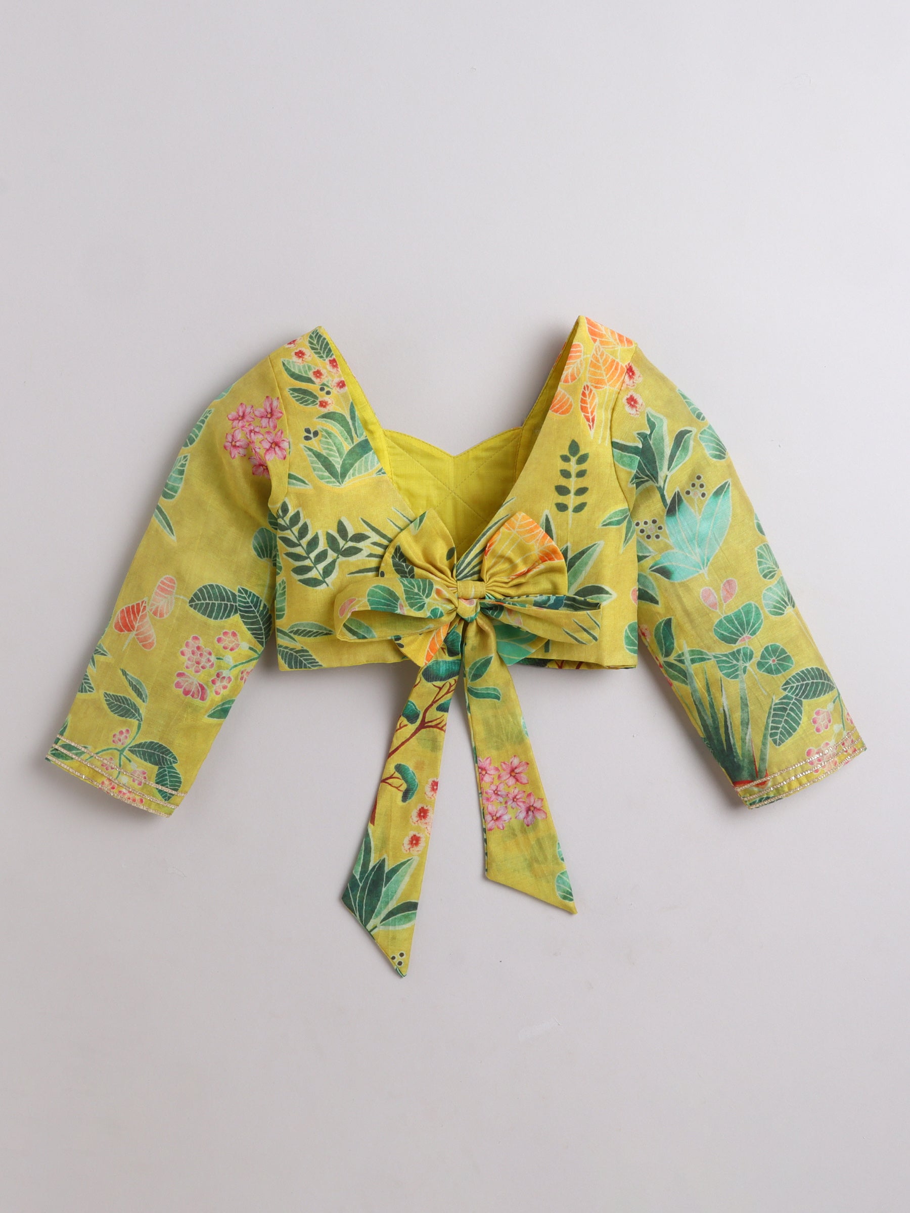 Yellow floral crop top with a knot on a light gray background