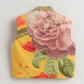 Floral patterned fabric with a prominent pink rose on a yellow background