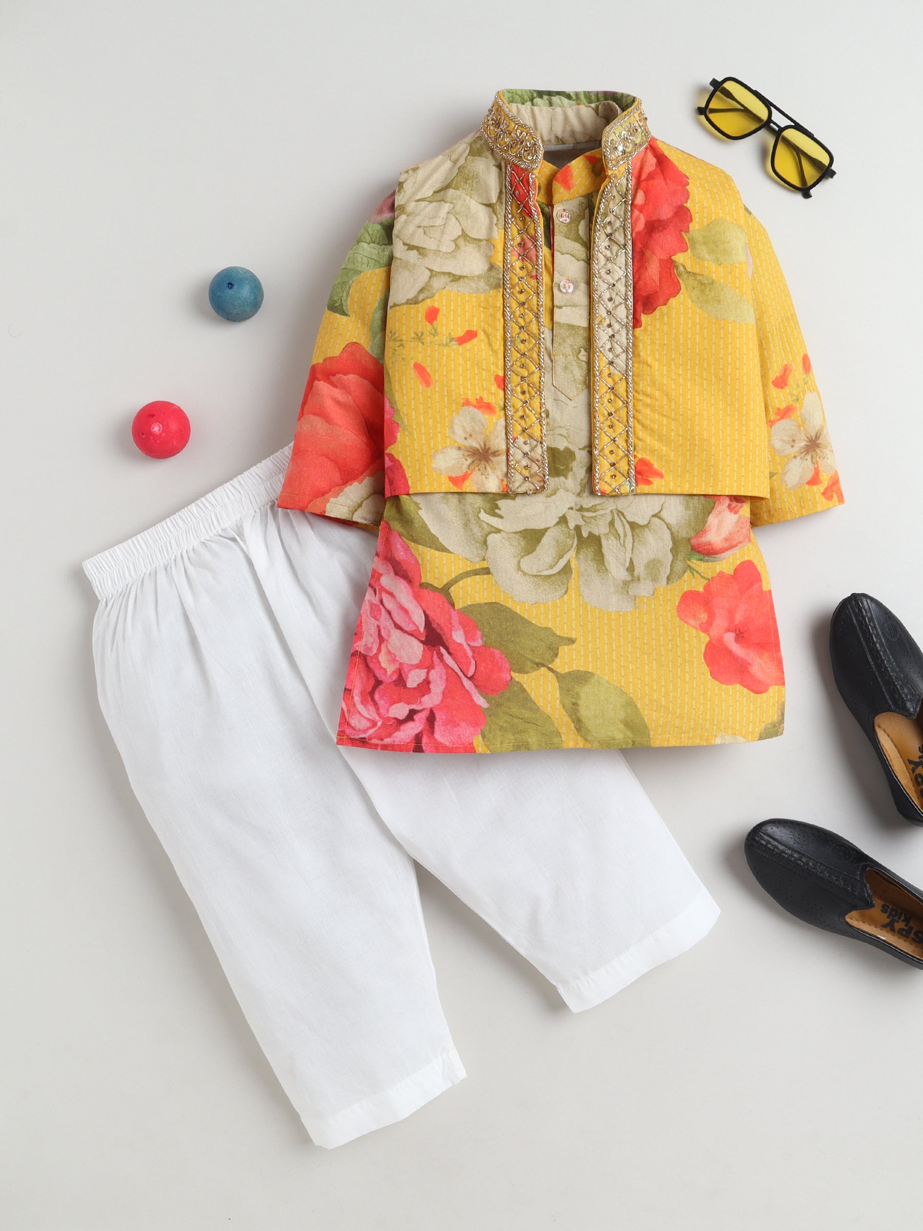 Colorful floral top with white pants on a light gray background