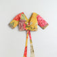 Colorful floral-patterned crop top with a tie detail on a light gray background