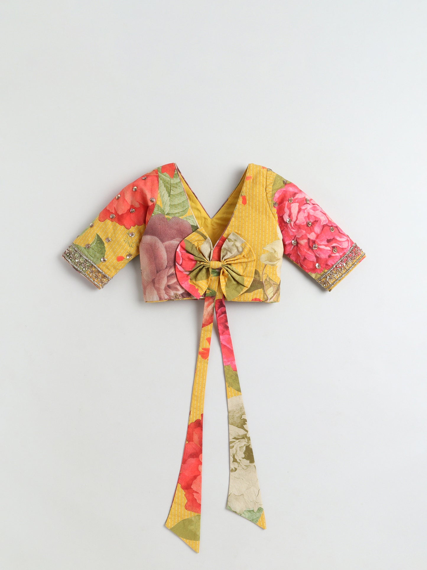 Colorful floral-patterned crop top with a tie detail on a light gray background