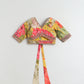 Colorful floral-patterned top with a tie detail on a light gray background