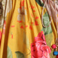 Close-up of a colorful floral dress with a yellow background