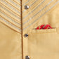 Close-up of a beige jacket with decorative buttons and a pocket featuring a red and gold handkerchief.