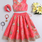 Coral pink traditional outfit with floral patterns on a light gray background