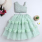 Mint green dress with ruffled layers on a white background