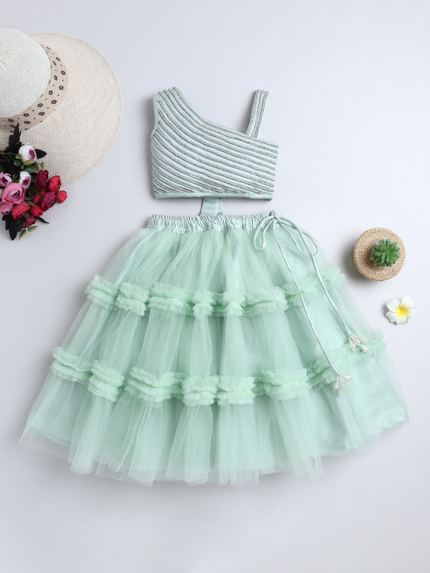 Mint green dress with ruffled layers on a white background