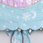 Close-up of a piece of fabric with floral embroidery and decorative elements on a light gray background.