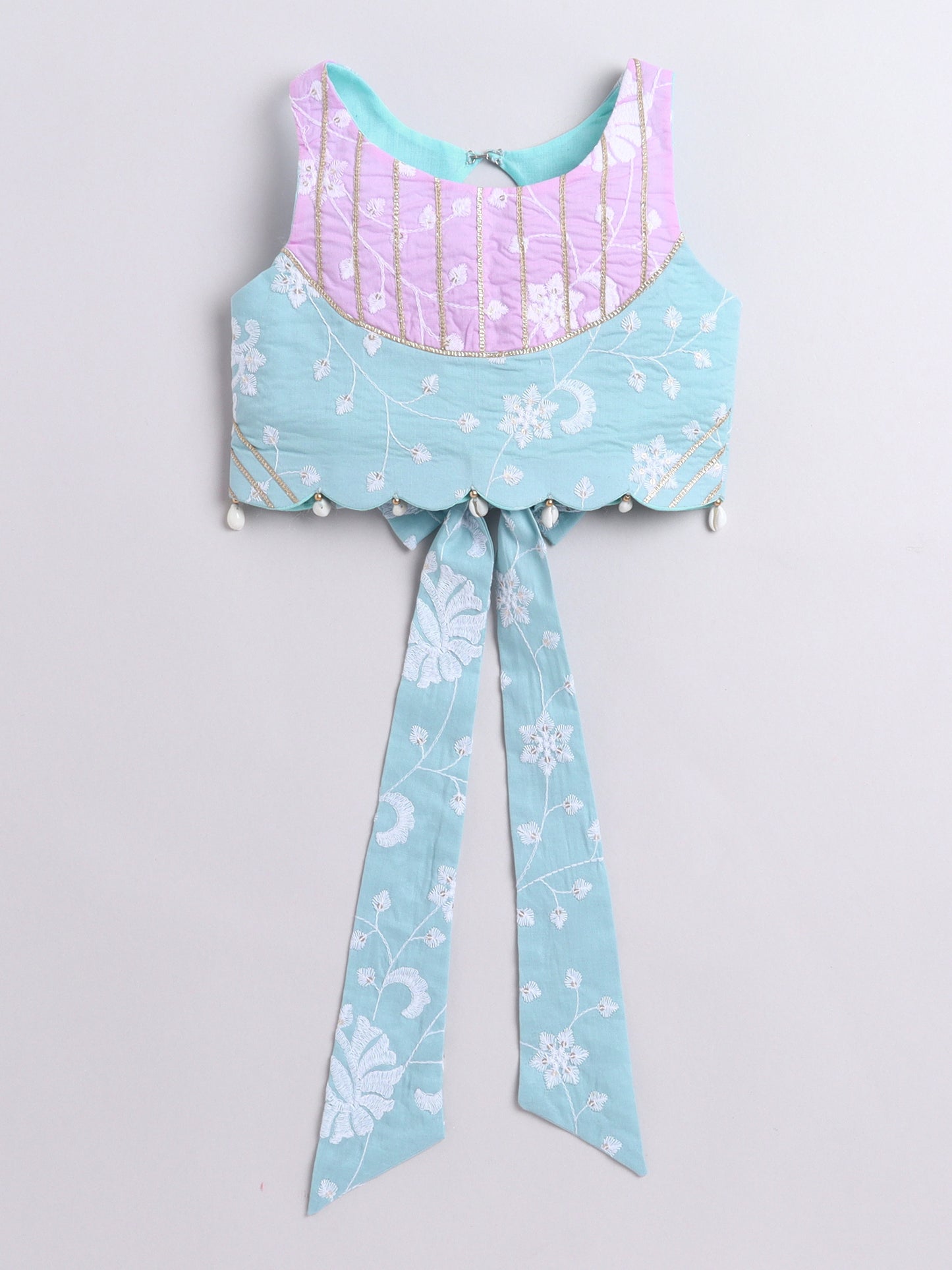 Light blue and pink top with floral patterns on a light gray background