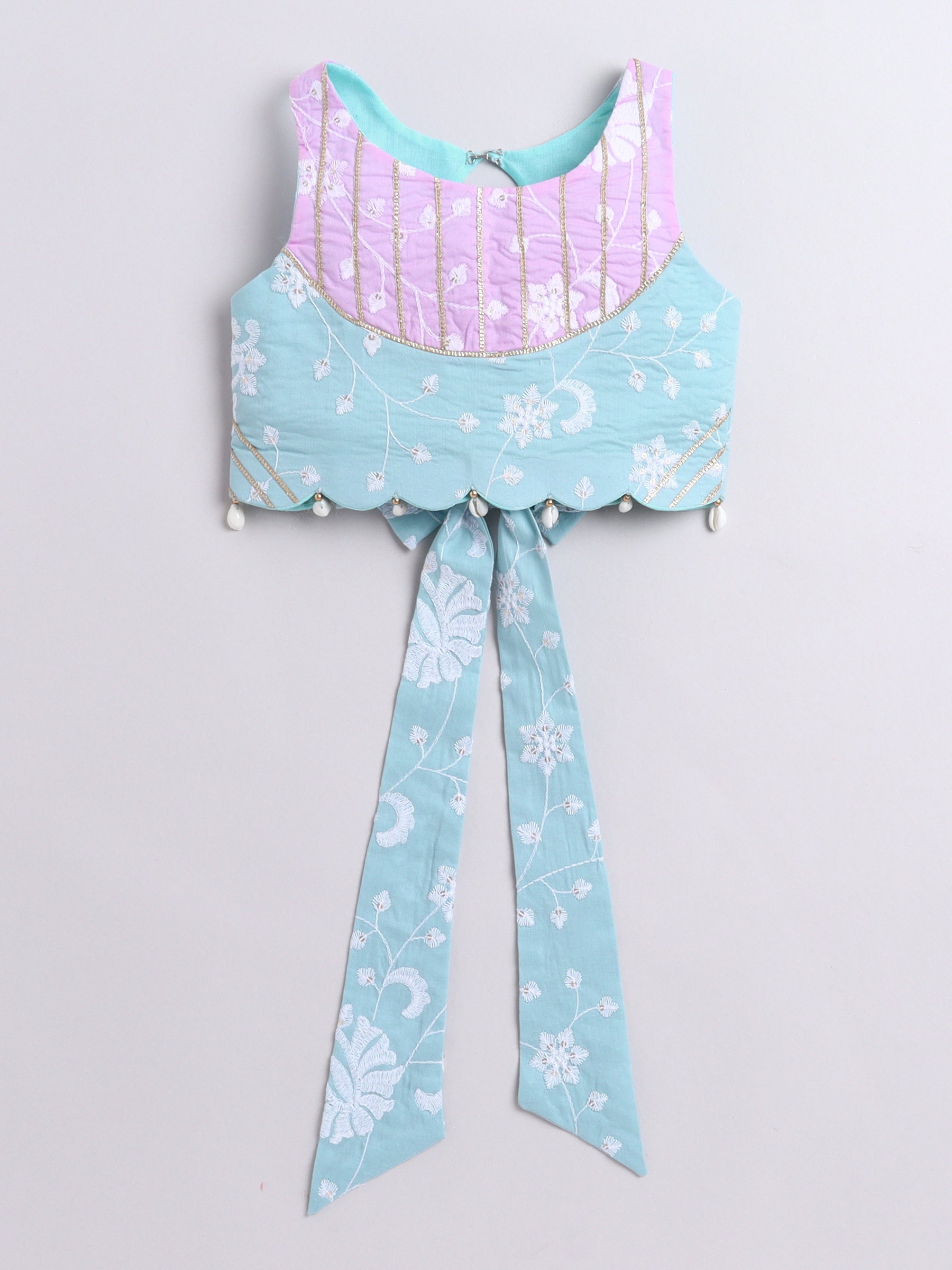 Light blue and pink top with floral patterns on a light gray background
