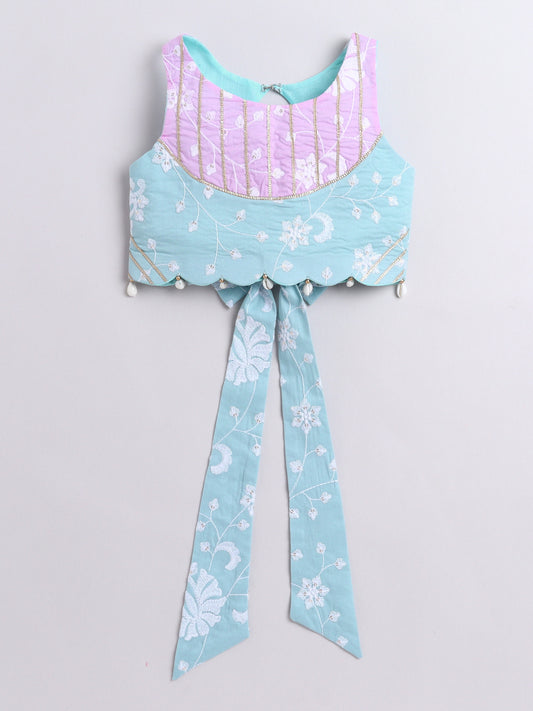 Light blue and pink top with floral patterns on a light gray background