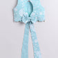 Light blue floral top with a large bow on a light gray background