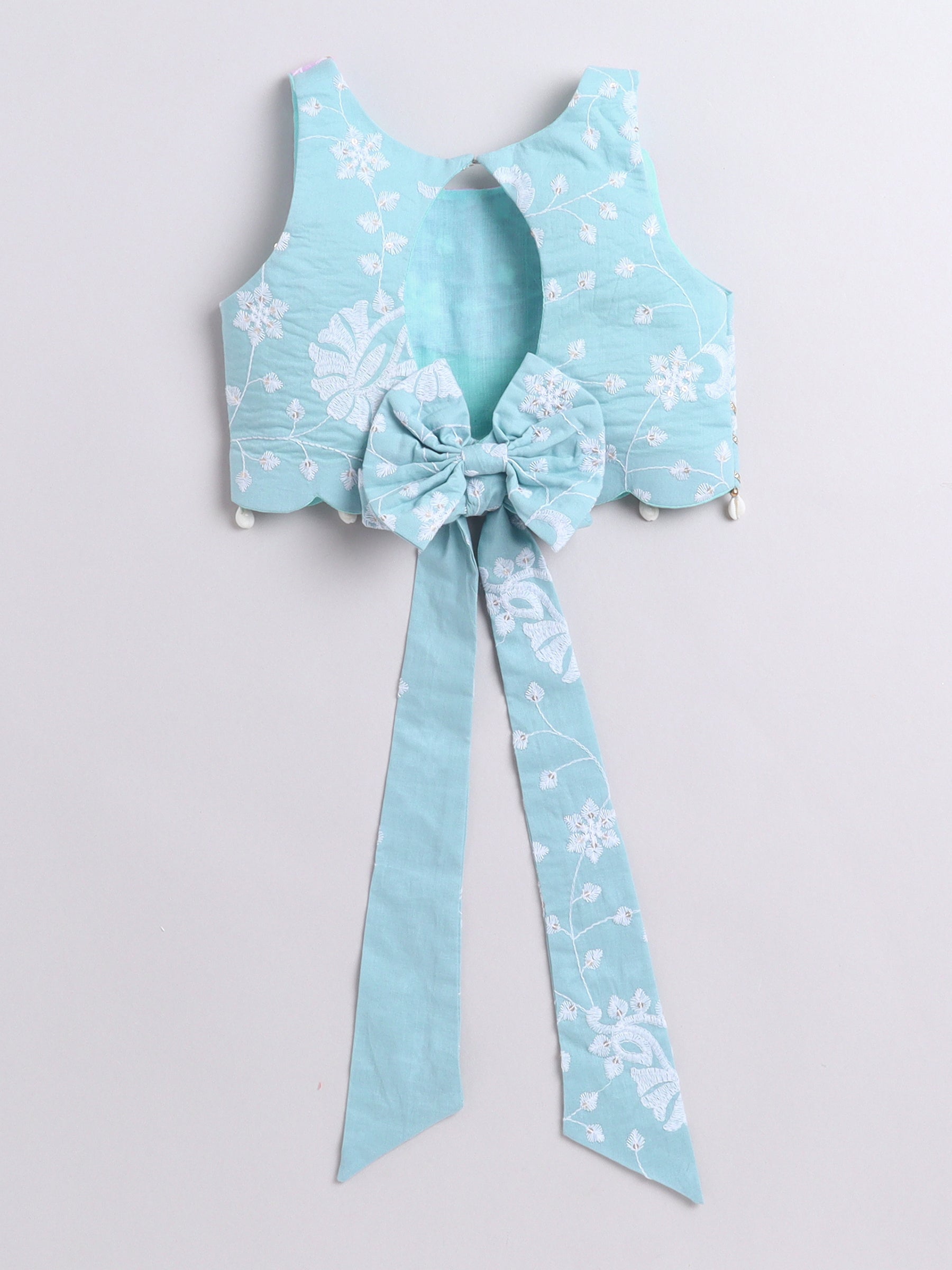Light blue floral top with a large bow on a light gray background