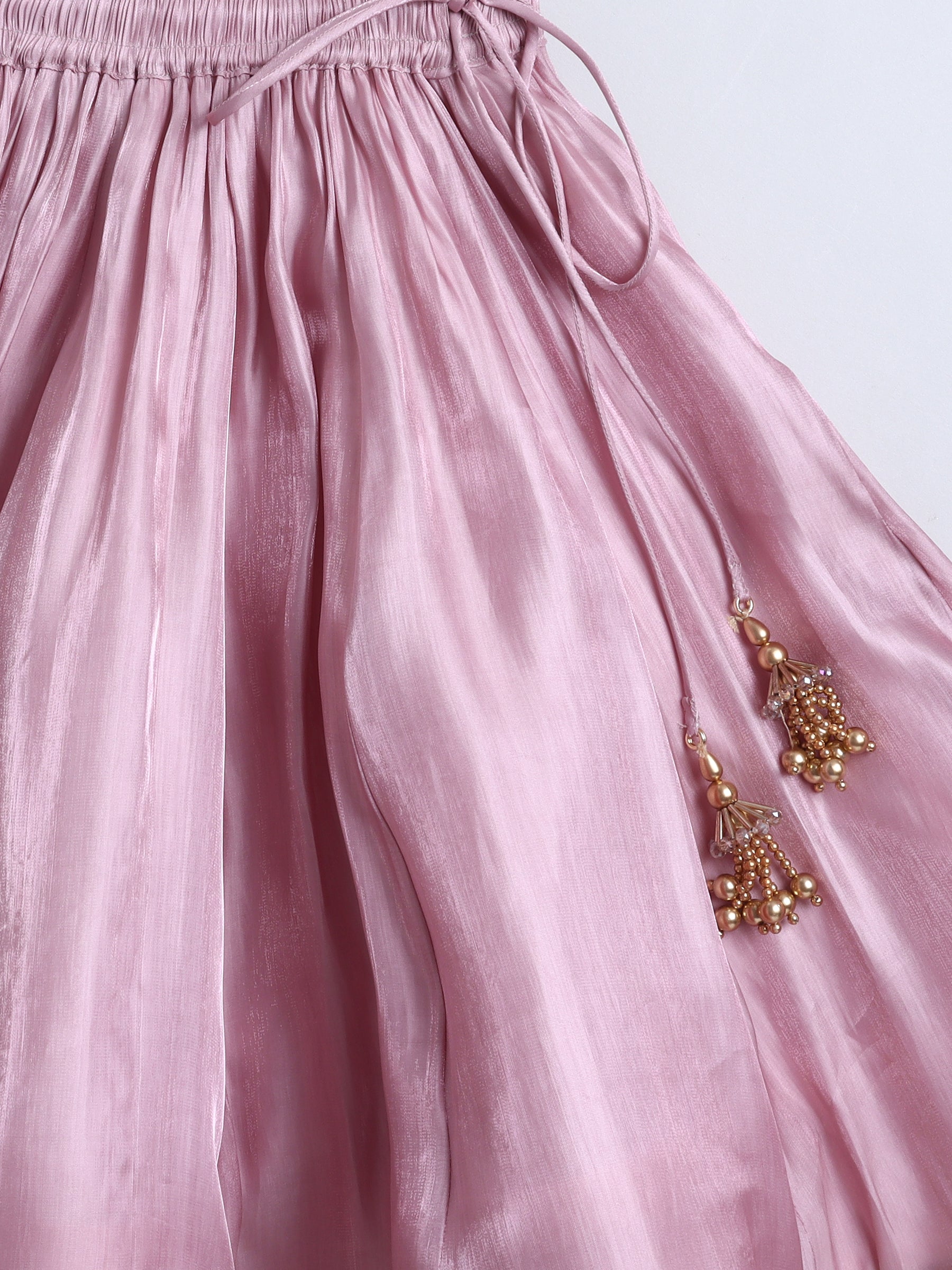 Pink fabric with gold earrings on a white background