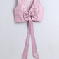 Pink crop top with a large bow on a light gray background