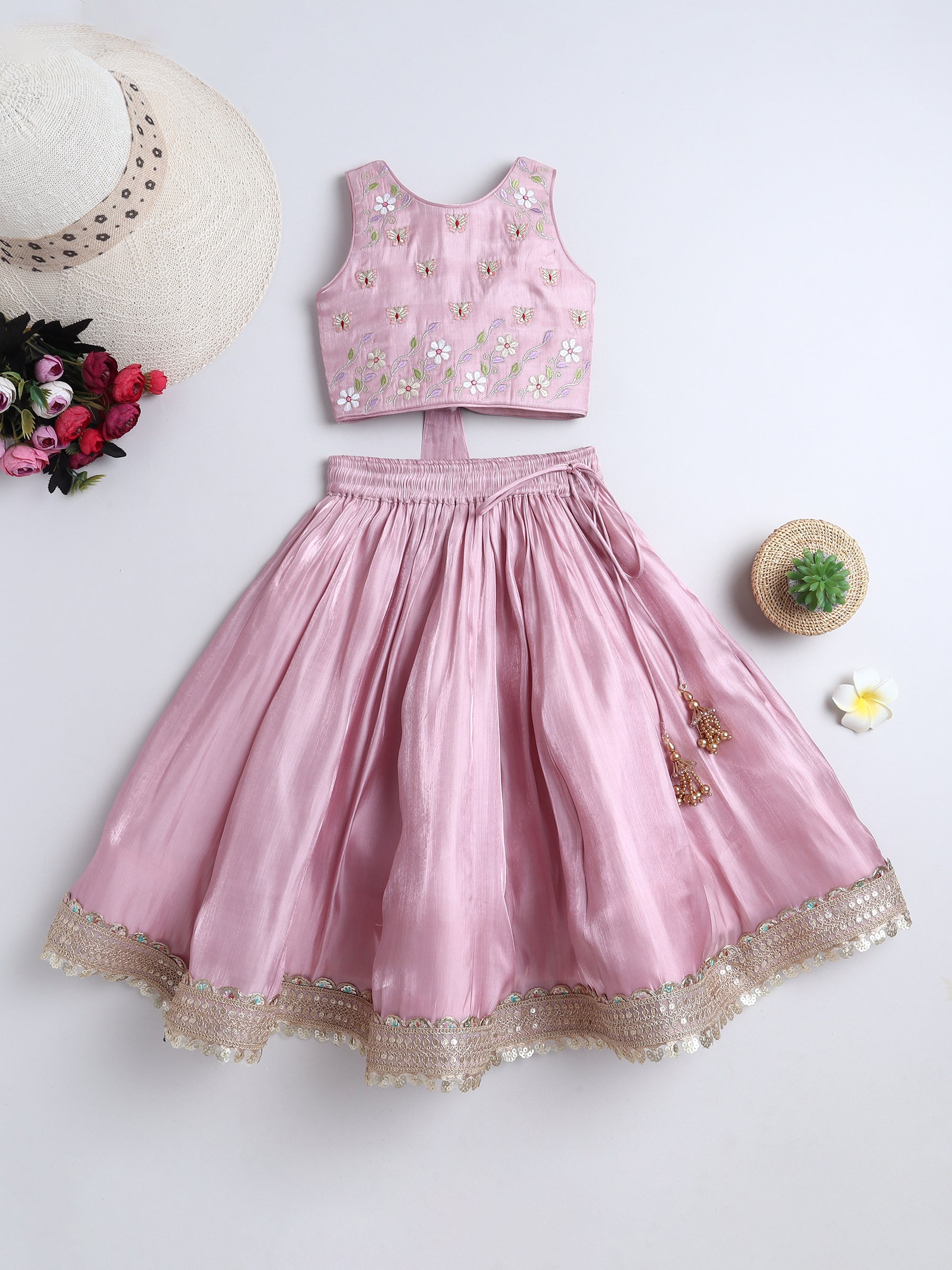 Pink children's outfit with floral top and skirt on a white background