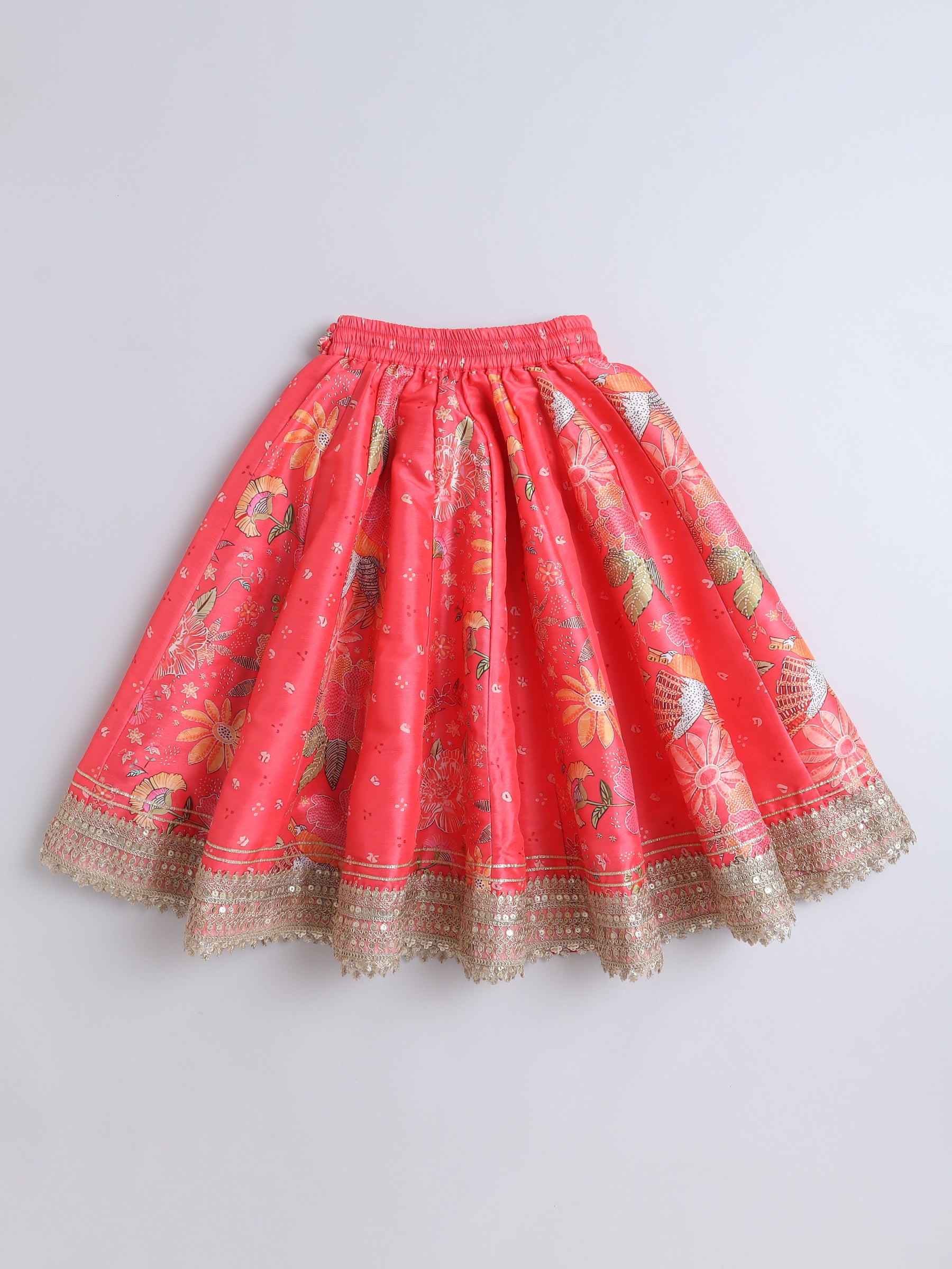 Red skirt with floral patterns and gold trim on a light gray background