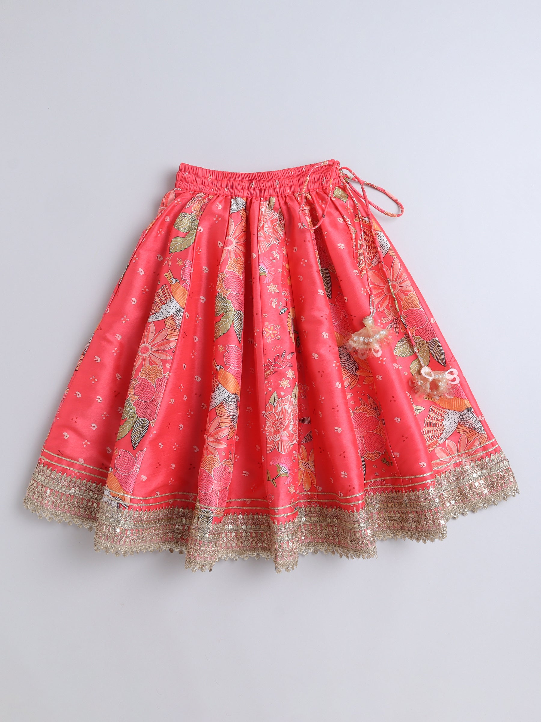 Red skirt with floral patterns and gold trim on a light gray background