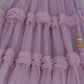 Close-up of a lilac tulle lehenga skirt with decorative gold tassel.