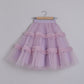 Lavender tulle skirt with ruffles on a wooden hanger against a plain background