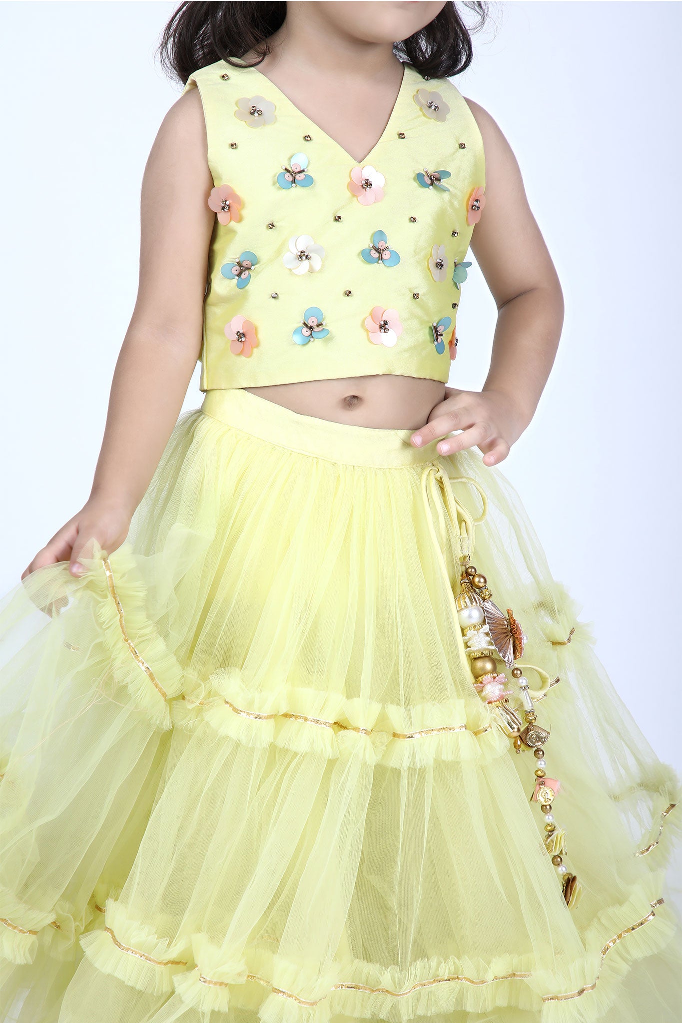 Close-up of sleeveless yellow choli with colorful 3D floral embroidery and V-neckline for girls